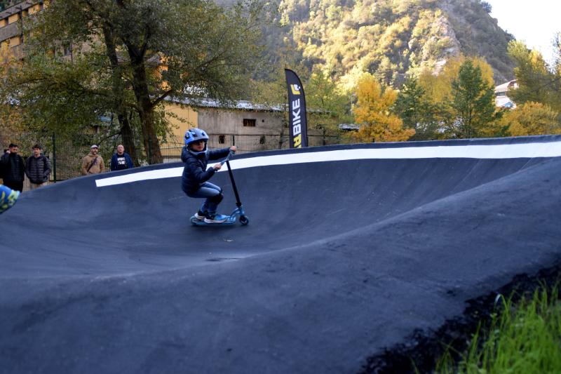 Un nen amb un patinet estrenant el pump track de Sant Julià de Lòria