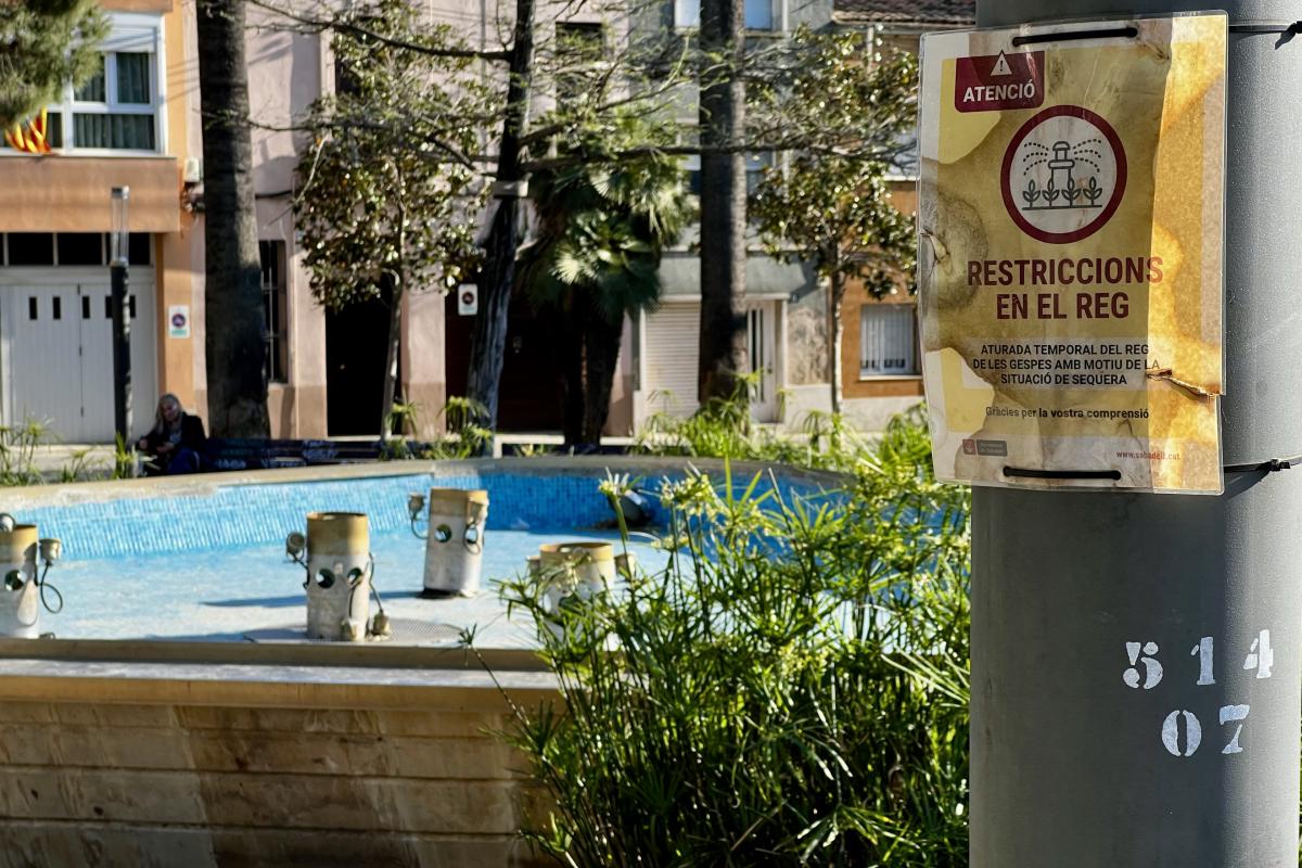 Font de la plaça de les Dones del Tèxtil de Sabadell amb un cartell de restriccions en el reg per la sequera