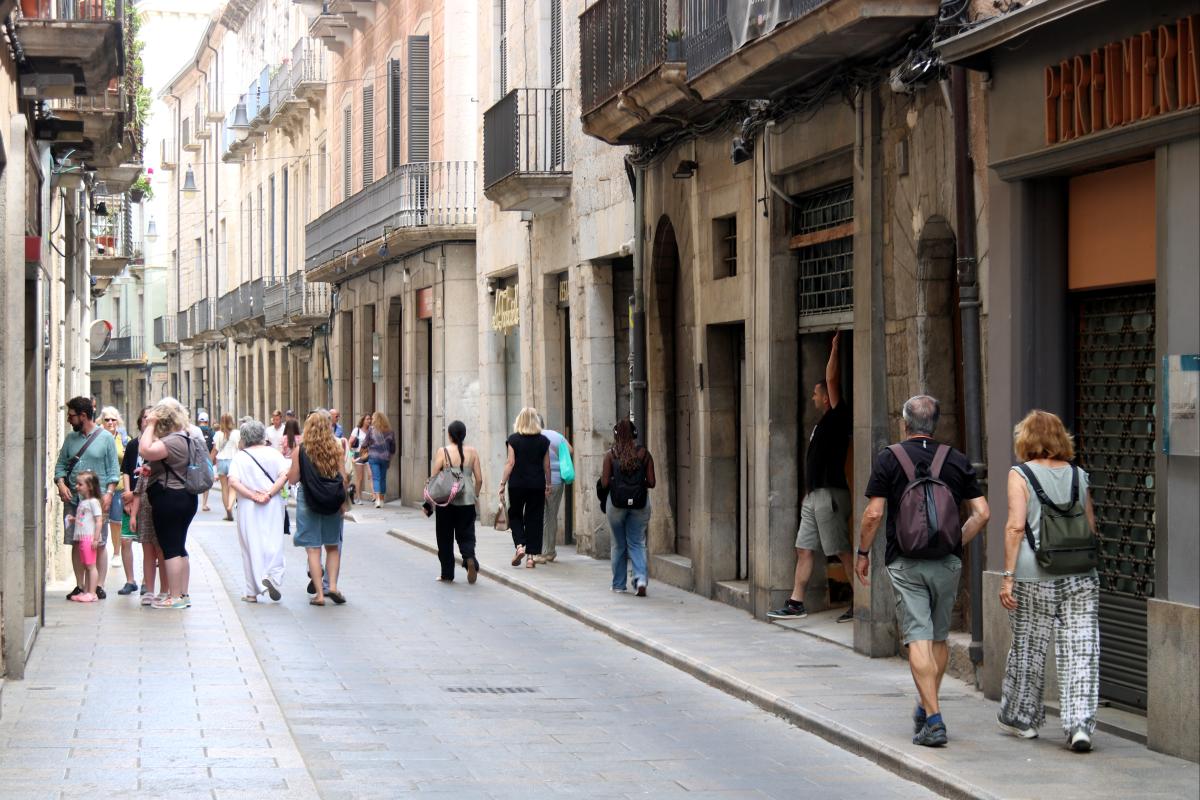 Gent passejant pel carrer Ciutadans de Girona, al Barri Vell de la ciutat
