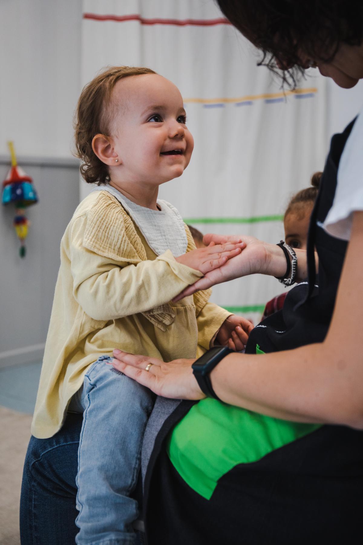 Una nena jugant amb la seva cuidadora en una llar d'infants