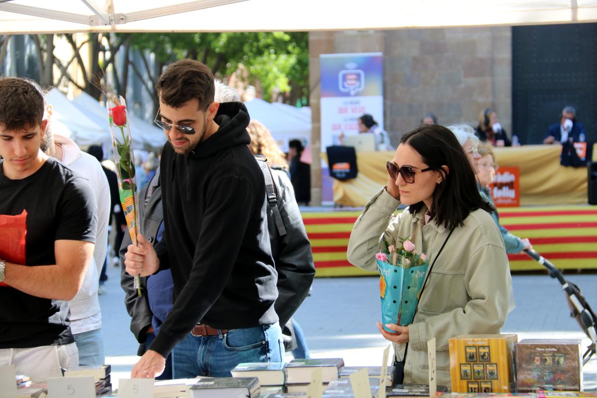 Una parella, rosa en mà, mirant llibres a Sant Feliu de Llobregat