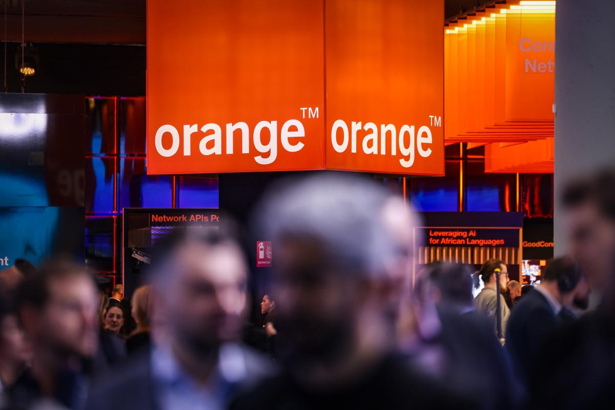 Assistents al MWC davant del logo d'Orange