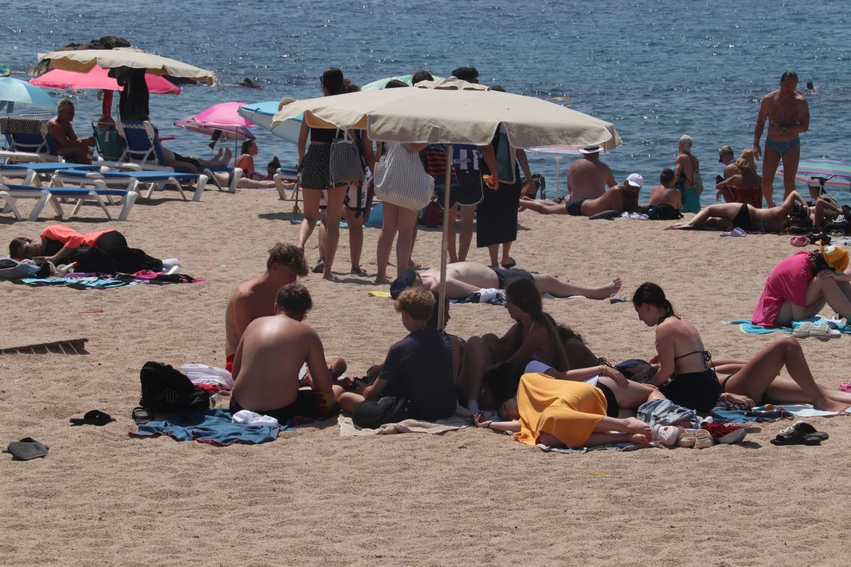 Un grup de turistes para el sol a la platja de Fenals de Lloret de Mar