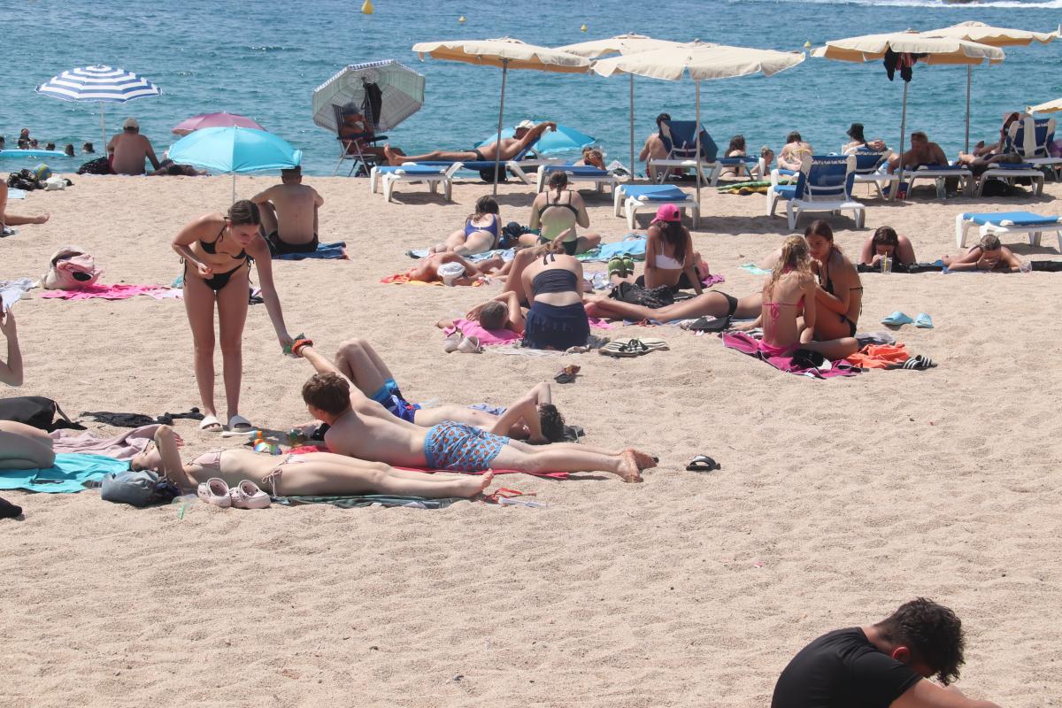 Alguns banyistes estirats a la sorra de la platja de Fenals de Lloret de Mar