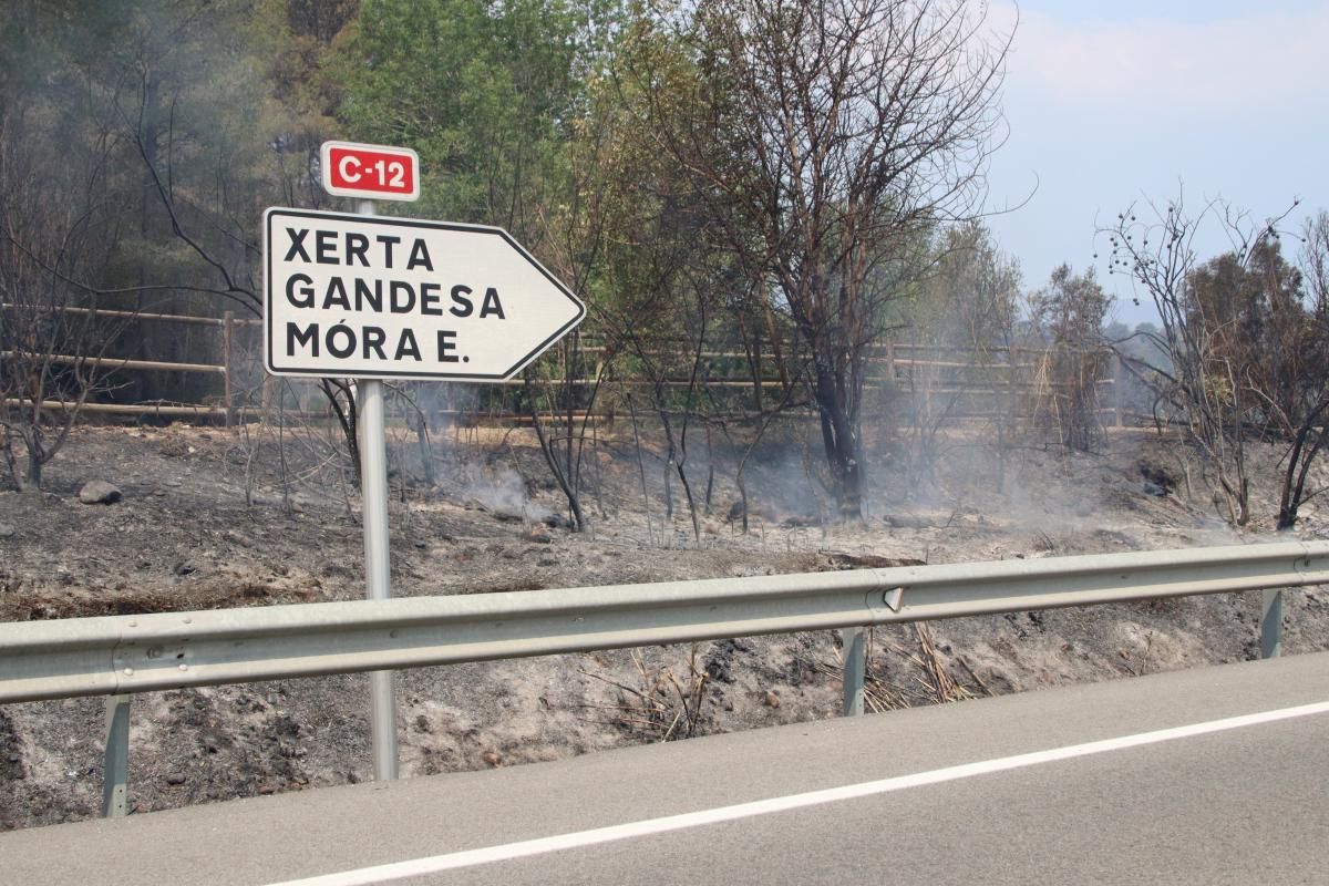 Cartell a la C-12 a l'alçada d'Aldover, amb el voral cremat i encara fumejant, aquest dimarts al migdia