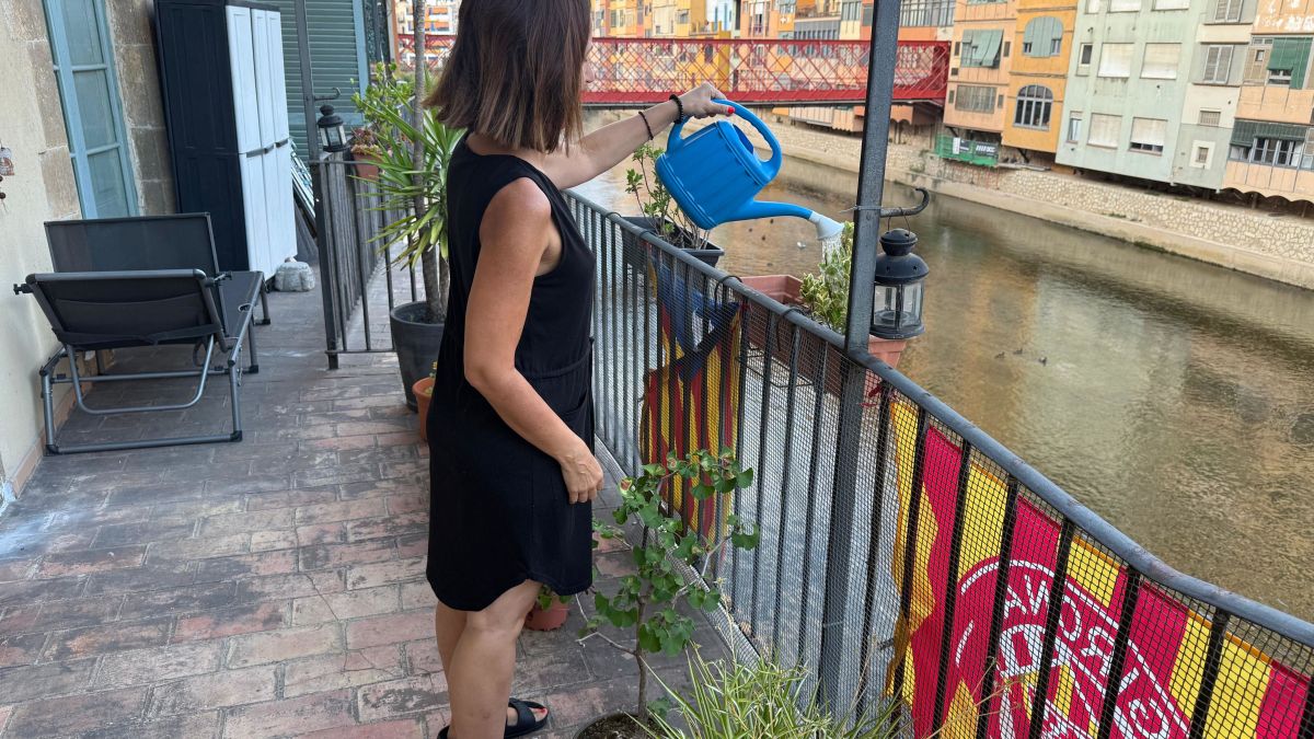 Una veïna rega les plantes al seu pis que dona al riu Onyar de Girona Una veïna rega les plantes al seu pis que dona al riu Onyar de Girona