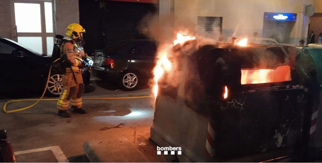 Imagen de archivo de un bombero apagando un fuego en un contenedor