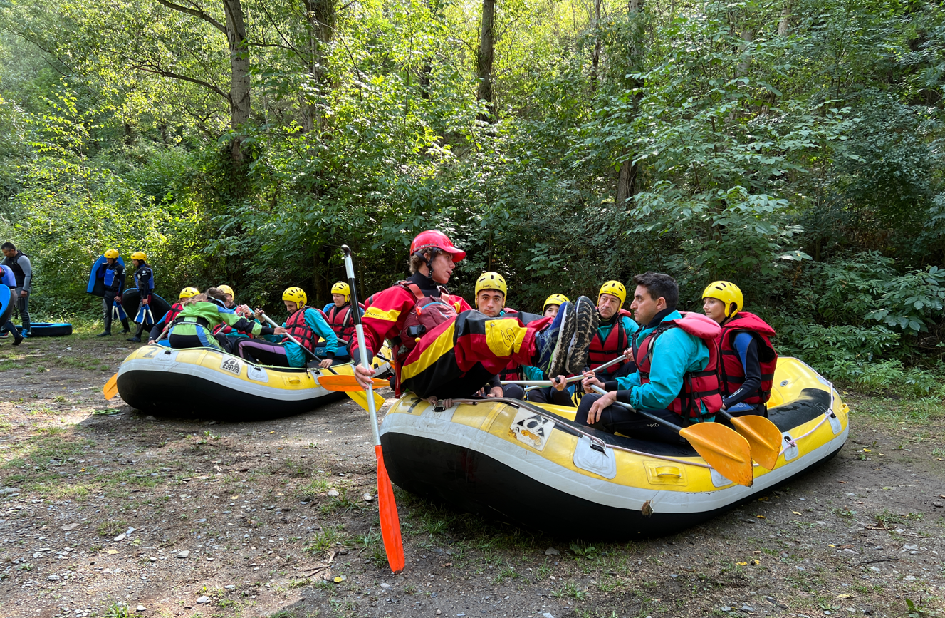 Diversos grups de turistes aprenent les tècniques del ràfting abans d'entrar al riu Noguera Pallaresa a Llavorsí