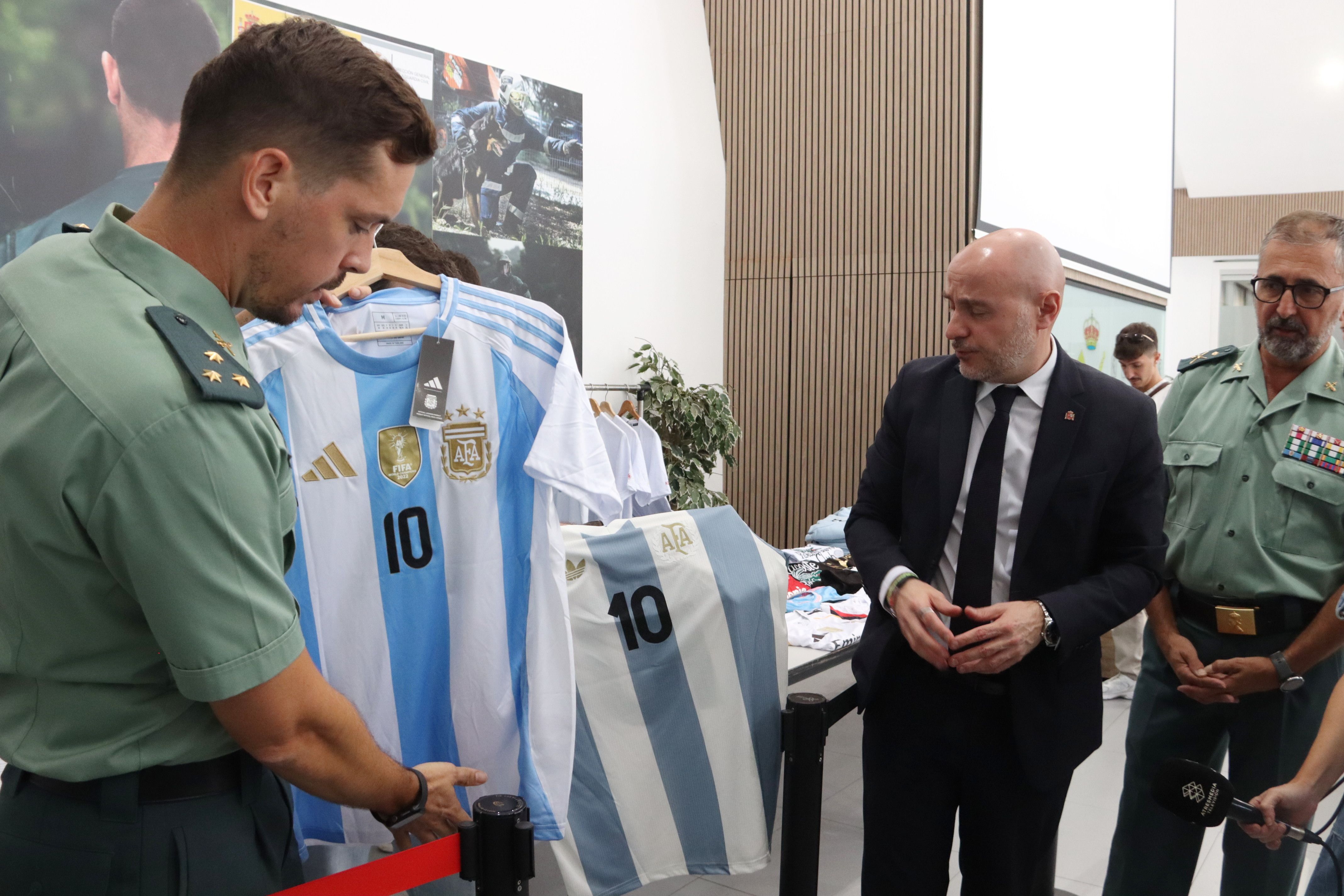 ACN / El cap de la Guàrdia Civil a Catalunya, Pedro Antonio Pizarro (dreta de la imatge); el capità Antoni Lorenzo i el delegat del govern espanyol, Carlos Prieto, mostrant samarretes amb el '10' de Messi, intervingudes en operacions contra el top manta