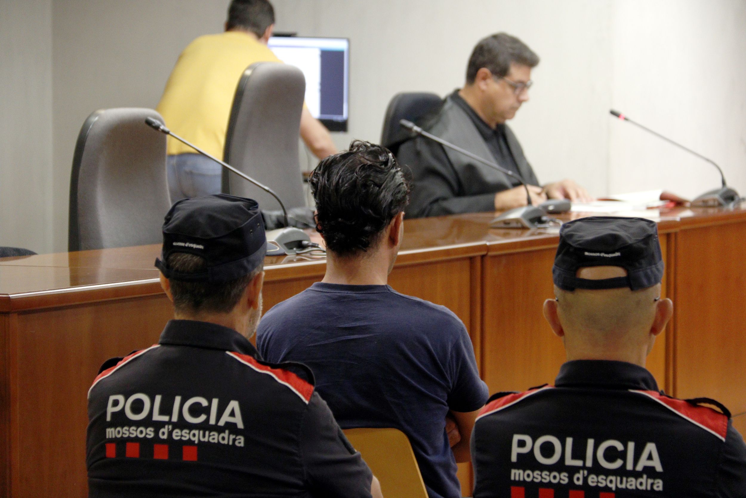 El acusado de agredir sexualmente a un chico en Lleida, durante el juicio en la Audiencia de Lleida, custodiado por los Mossos d'Esquadra