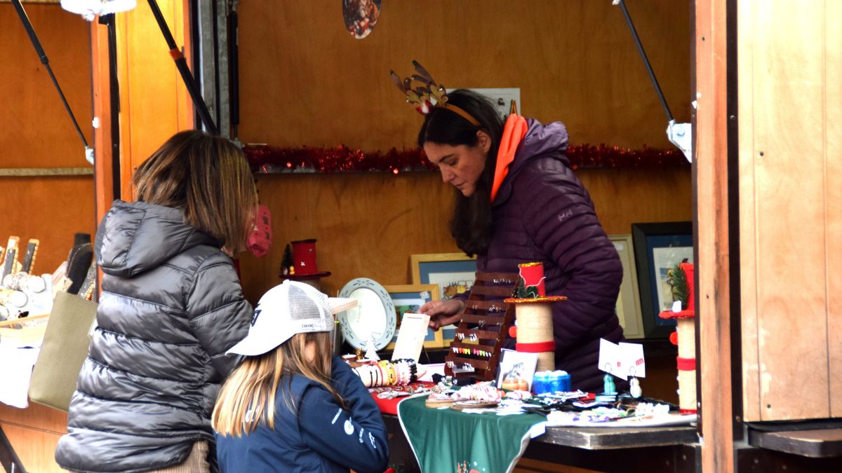 Una paradista de la fira de Santa Llúcia d'Encamp atenent a unes compradores (1)