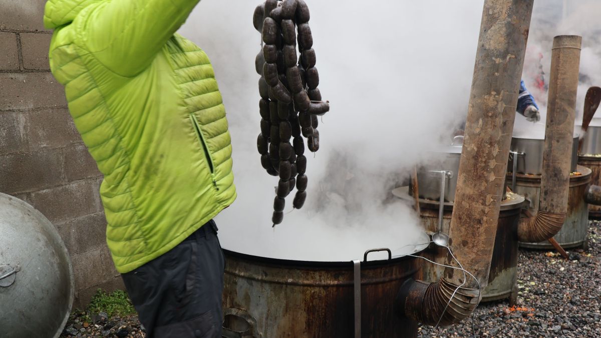 Un membre de la germandat traient la carn de l'olla