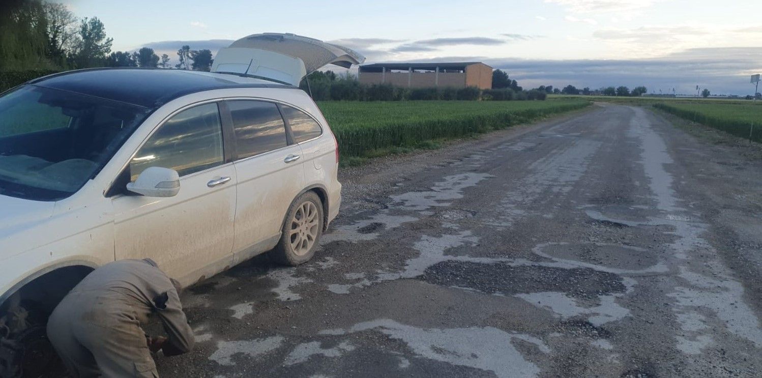 Un vecino reparando su vehículo tras ser dañado en el camino (Junts)