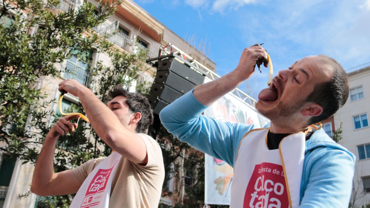 Dos homes endrapen calçots durant el concurs de menjar aquesta ceba dolça a Valls