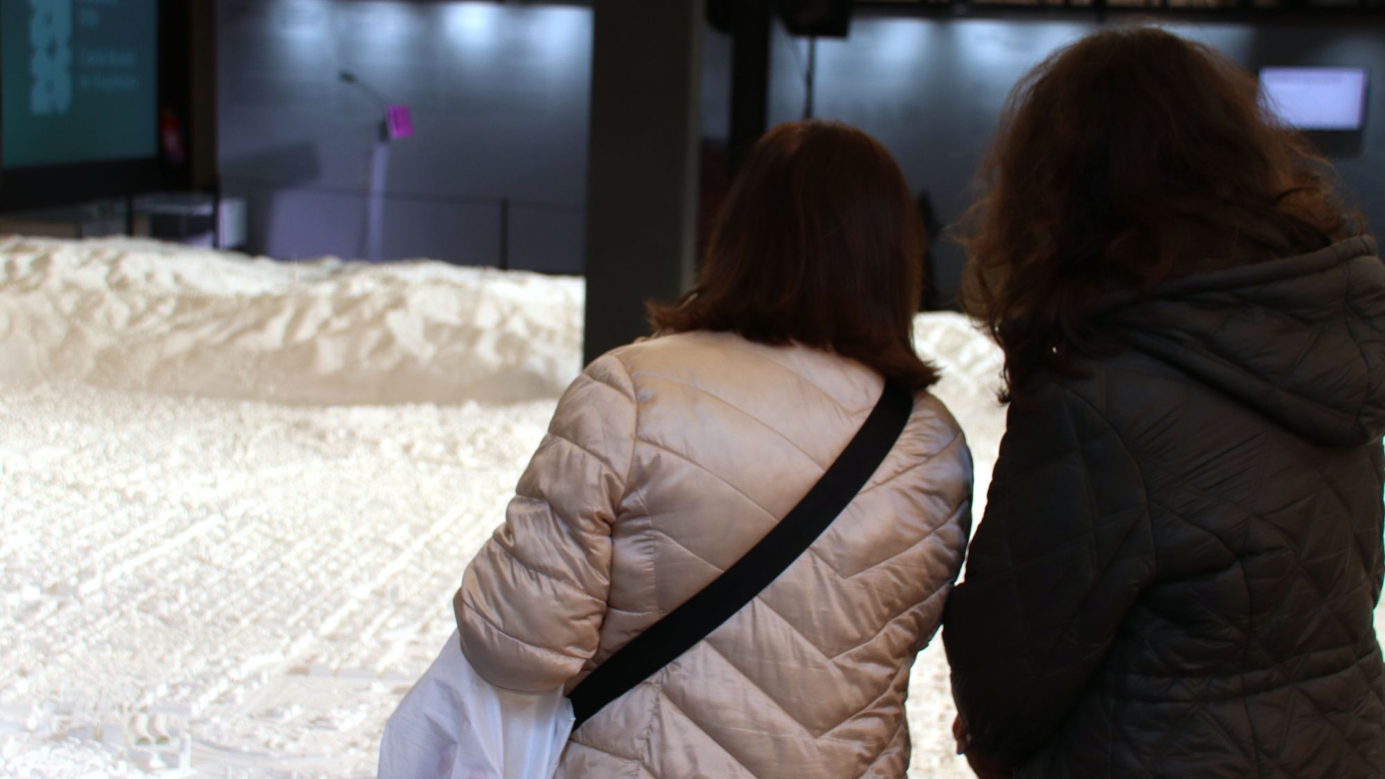 Dues persones observen la maqueta Pla de Barcelona exposada a l'antiga seu de l'Editorial Gustavo Gili