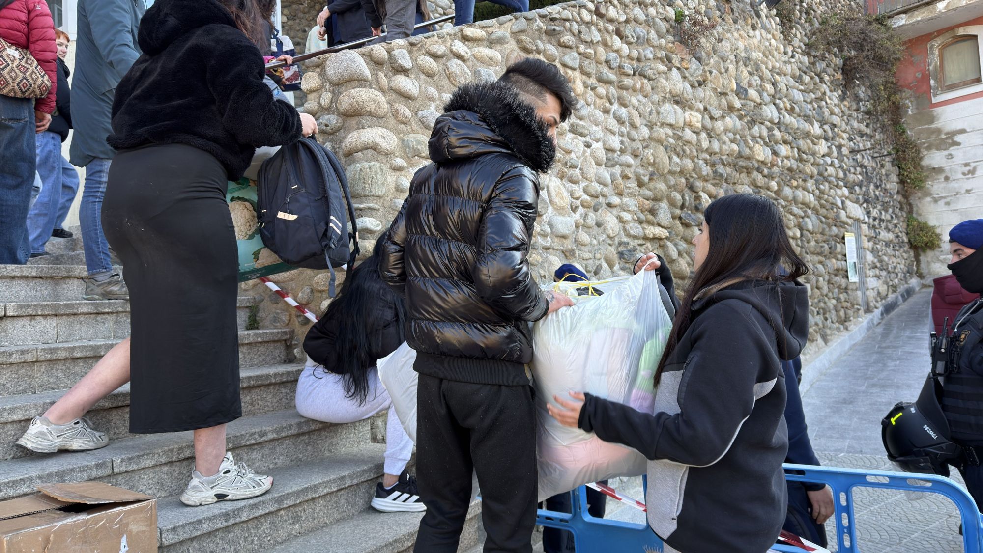 Diverses persones ajudant a retirar bosses amb pertinences dels veïns d'un bloc de pisos de Puigcerdà que ha estat desnonat