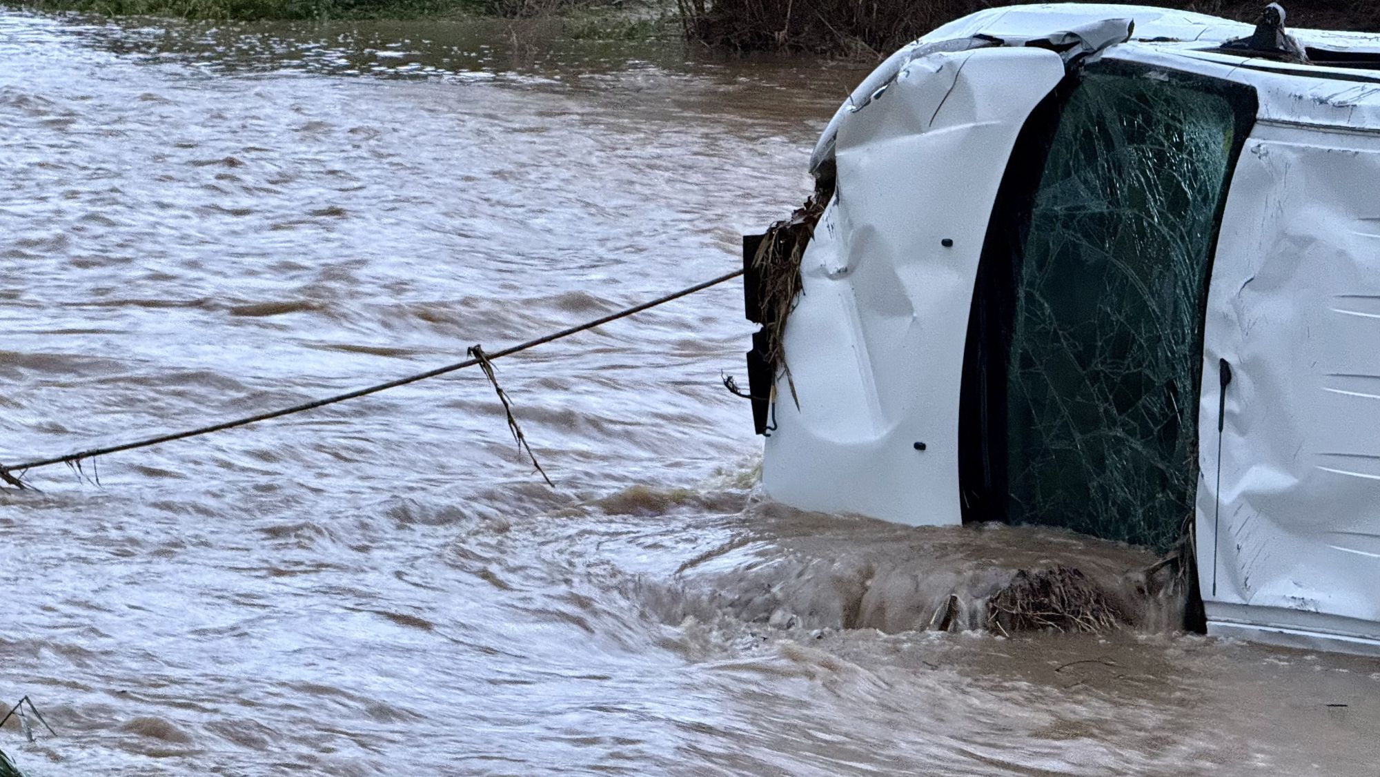 Un cable subjecta una furgoneta arrossegada per la riera Giola fins al riu Mogent a Llinars del Vallès