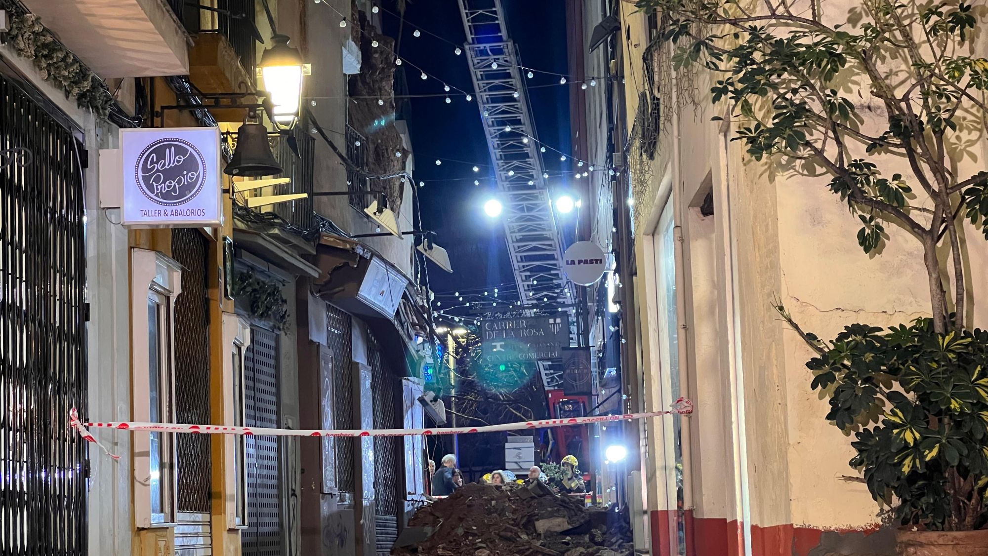 Els efectius de seguretat treballant al carrer on ha caigut la paret d'un edifici a Sabadell