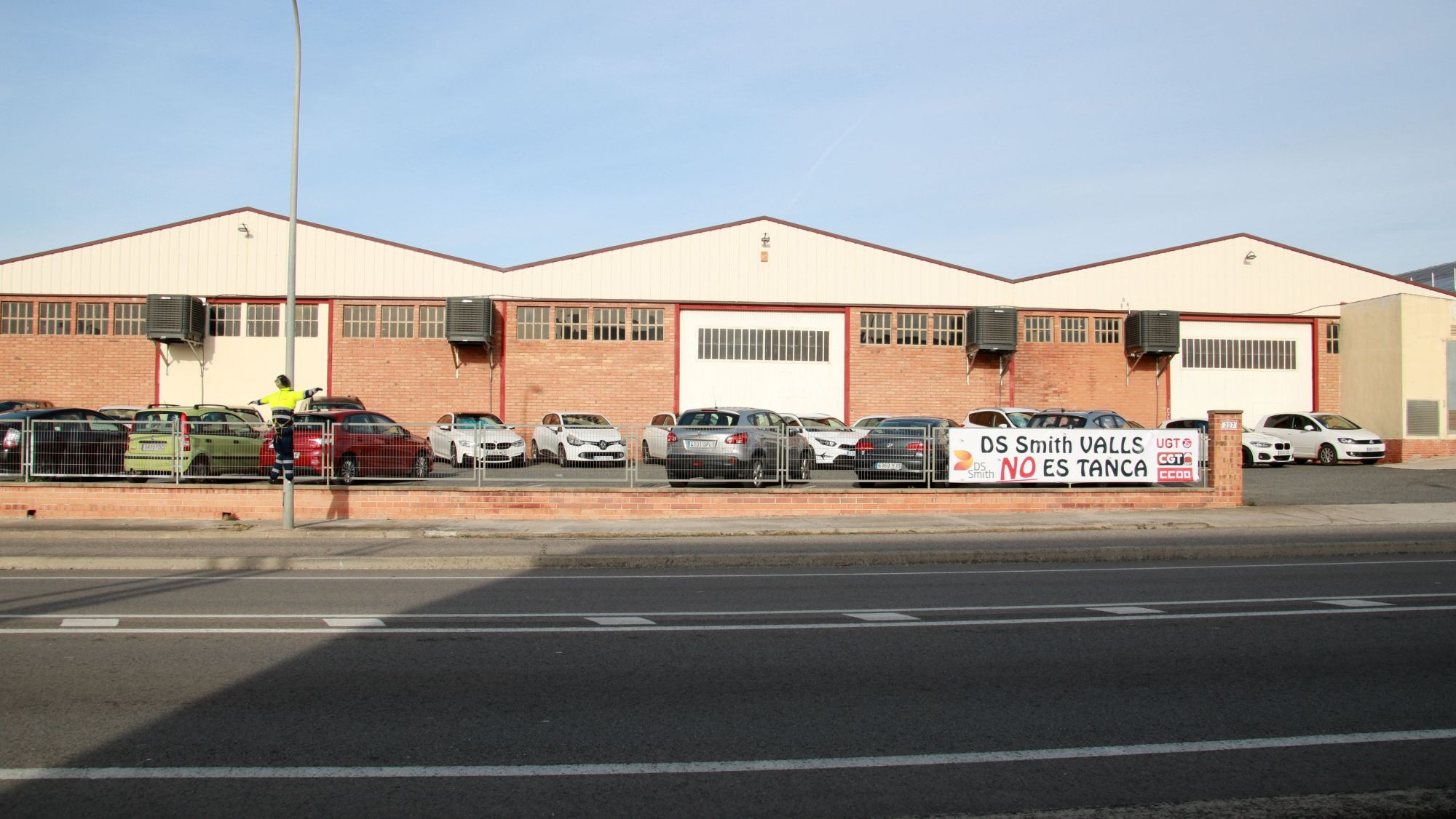L'exterior de la planta d'International Paper de Valls amb un cartell que denuncia el tancament