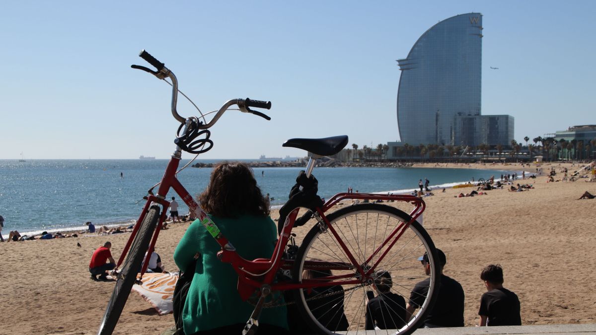 Una dona a la platja de Sant Miquel, amb l'Hotel W de fons