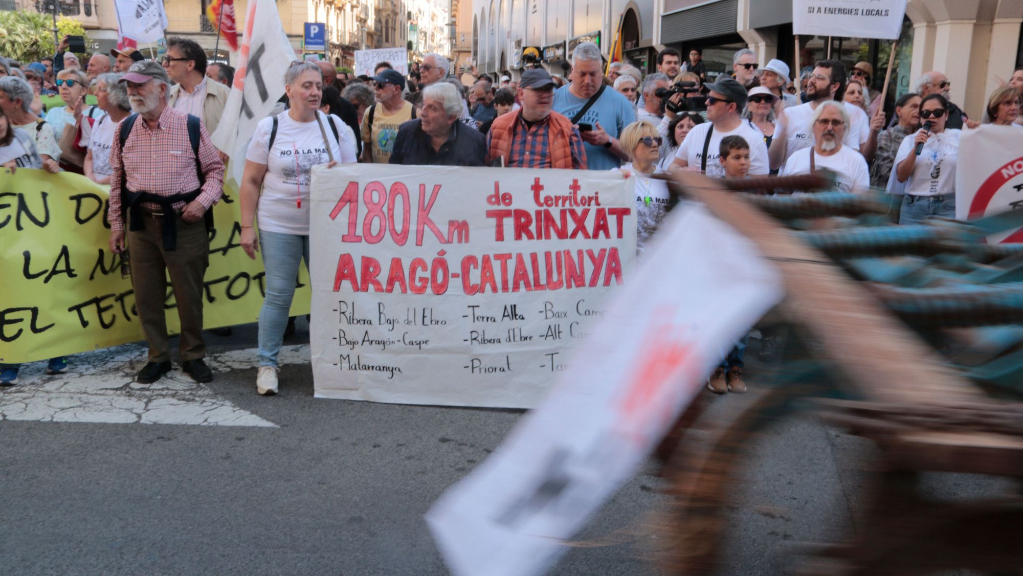 Un tractor passa per davant d'una de les pancartes contra la MAT a la marxa unitària de Reus
