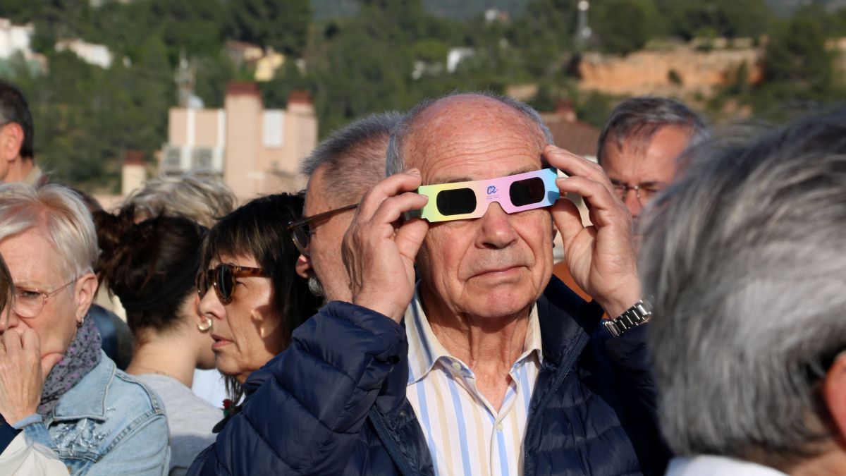Un dels assistents al taller de l'eclipsi a Tortosa observa el Sol amb les ulleres