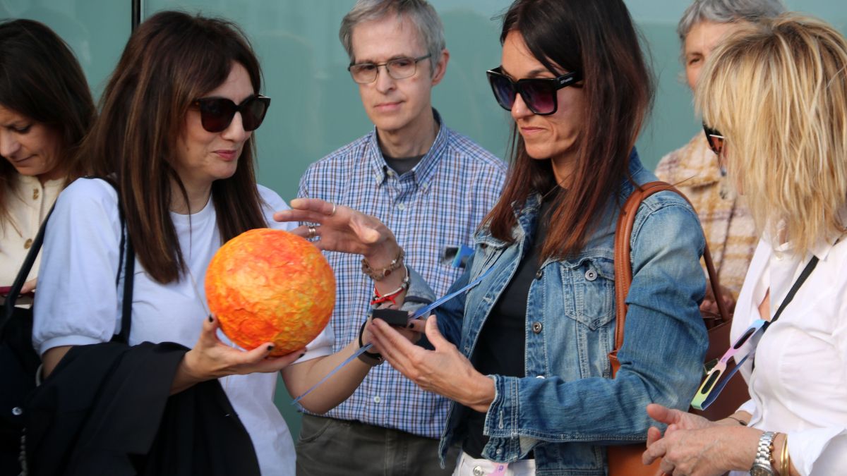 Dues participants al taller de l'eclipsi solar de la URV observen com es mouren els astres amb figures en miniatura