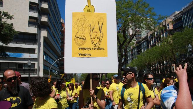 Mestres i professionals de la comunitat educativa amb un cartell reivindicatiu