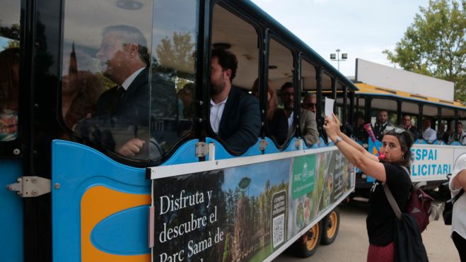 Una treballadora de l'ajuntament de Cambrils mostra una pancarta a les autoritats locals per denunciar la falta de personal i l'impagament d'endarreriments