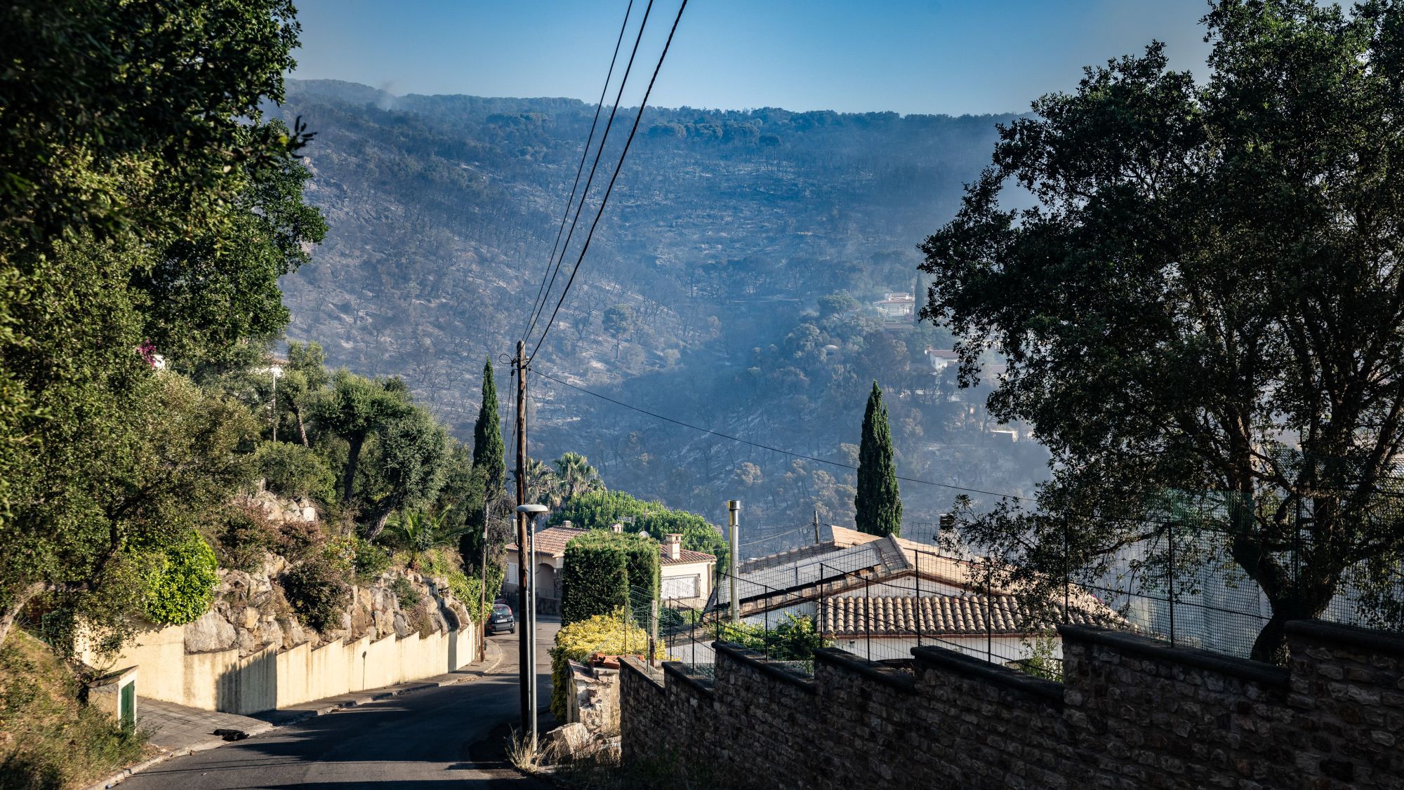 La urbanització de les Cabanyes, a Calonge, amb la muntanya arrasada per l'incendi de fons