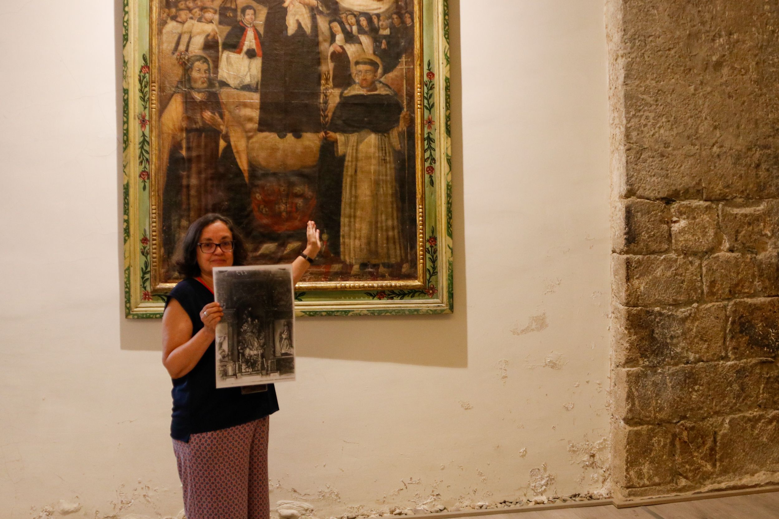 La documentalista y activista cultural Montserrat Riu muestra la fotografía que ha permitido redescubrir el desaparecido retablo barroco de la Mare de Déu del Roser de Organyà. Foto: Marc Codinas (ACN).