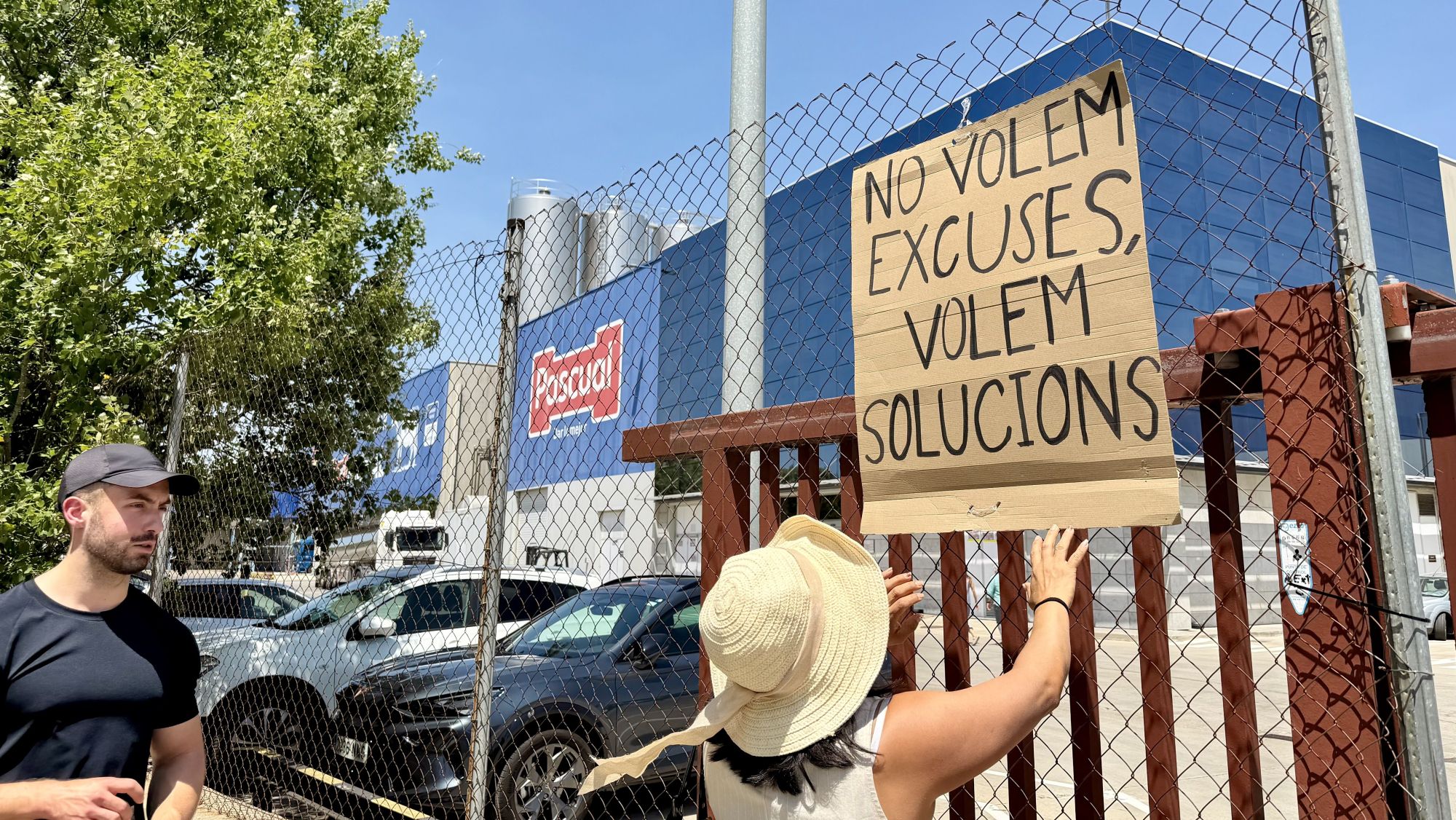 Una treballadora de Pascual col·loca una pancarta on es pot llegir 'No volem excuses, volem solucions'