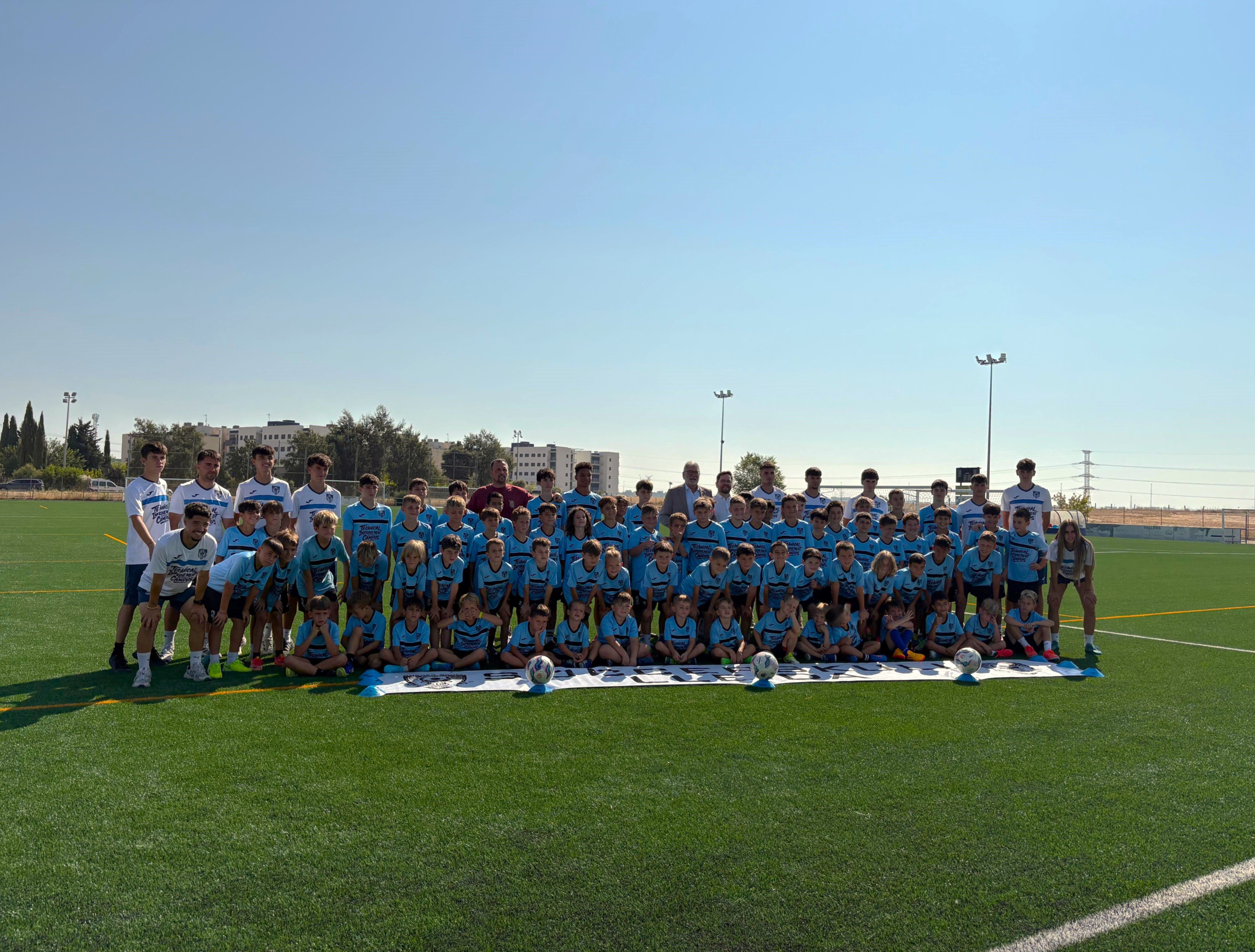 El alcalde de Lleida, Fèlix Larrosa, y el concejal Roberto Pino, con los niños y jóvenes del club durante la visita al campo de fútbol de los Mangraners.
