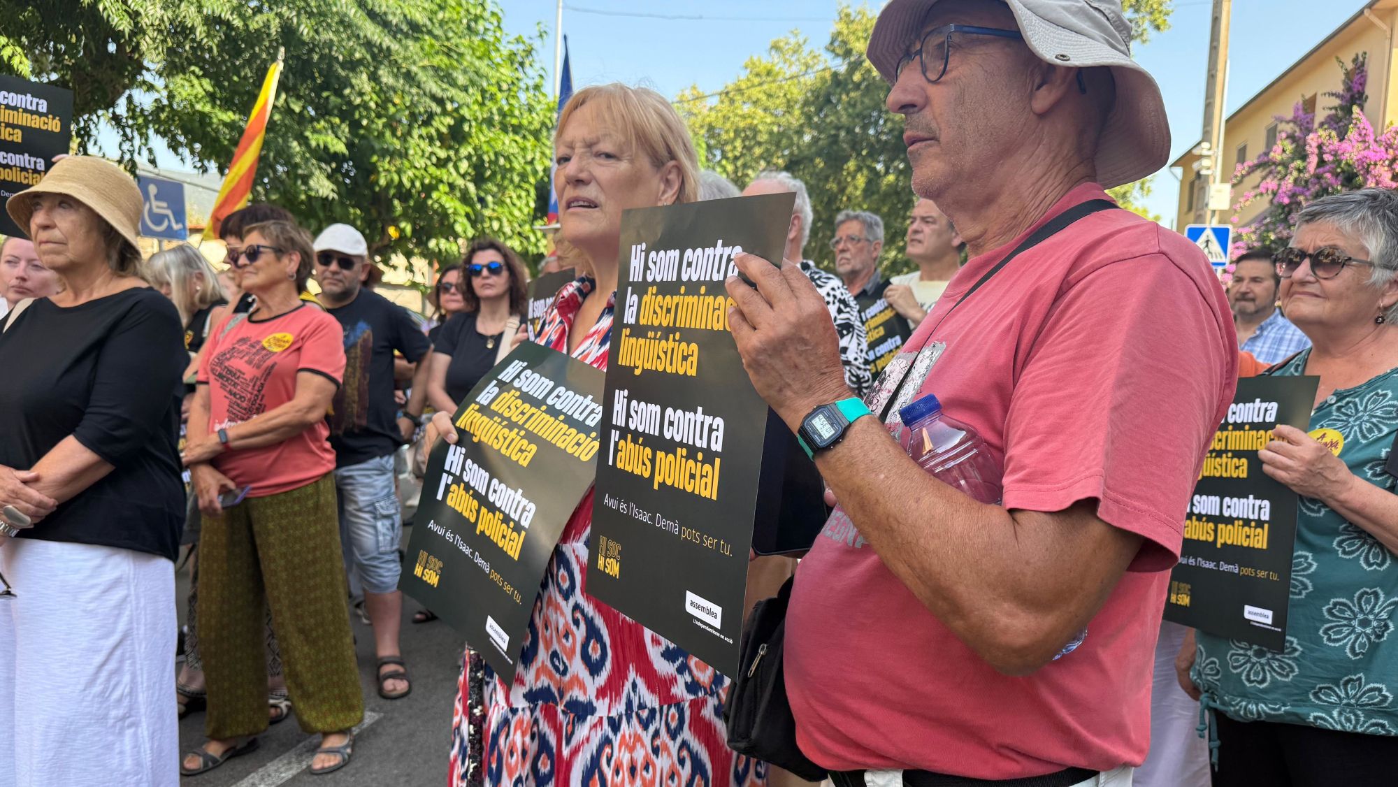 Dues persones amb un cartell en contra de la discriminació lingüística