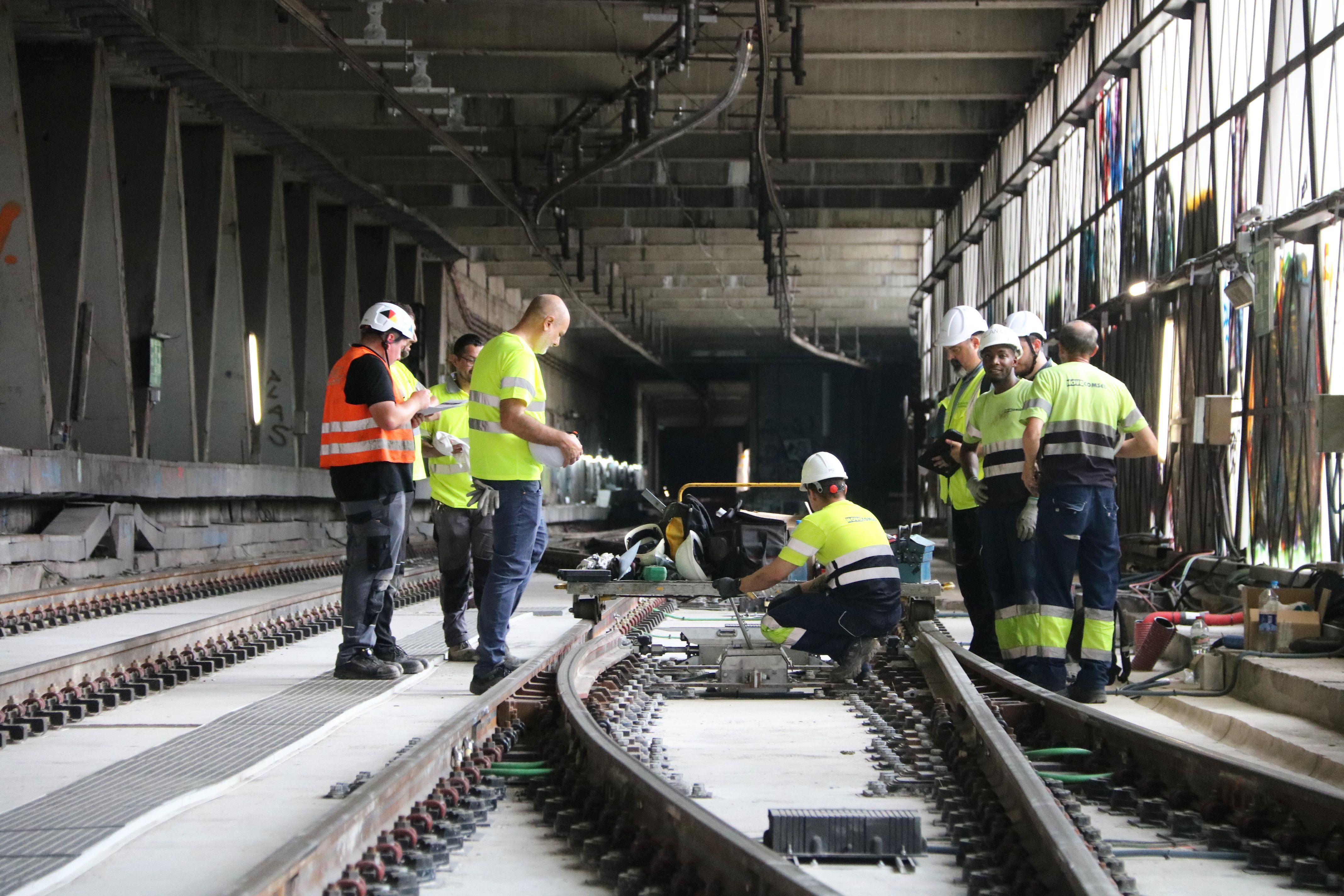 Obreros trabajando en vías de la L1 de la estación de Santa Eulàlia, situada entre Florida y Plaça de Sants.
