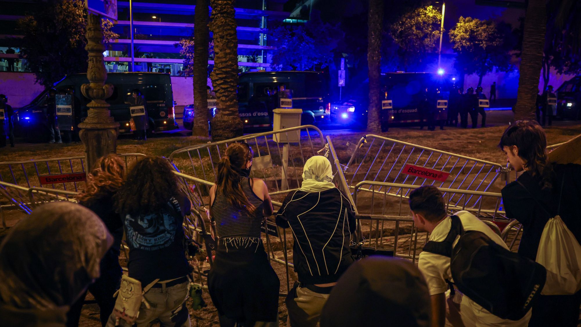 Activistes davant tanques a terra amb un cordó policial al fons en el marc d'una protesta per la crisi de l'habitatge davant del Palau de Congressos de Barcelona