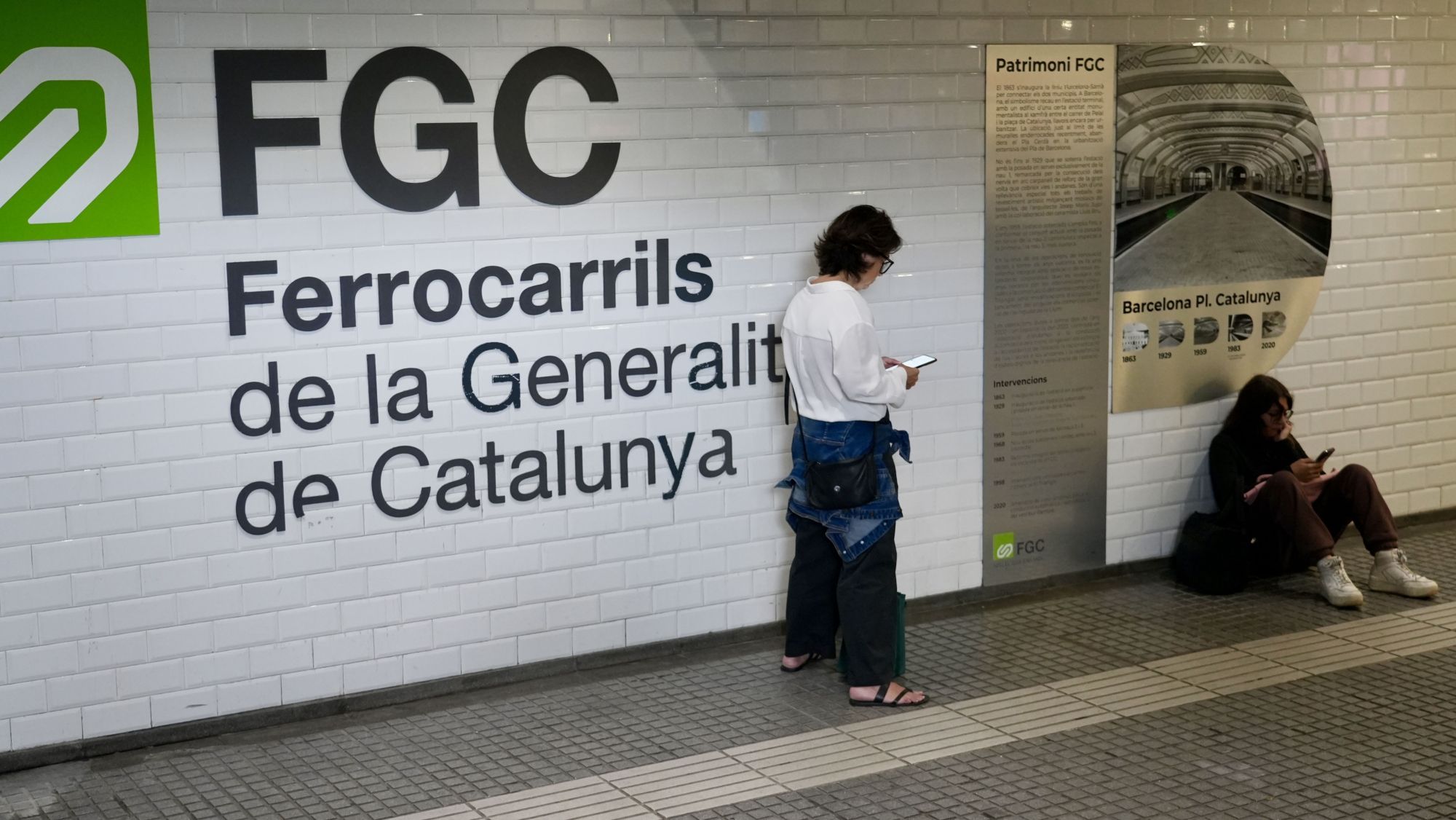 Dues noies esperant la reobertura del servei de FGC a Plaça Catalunya