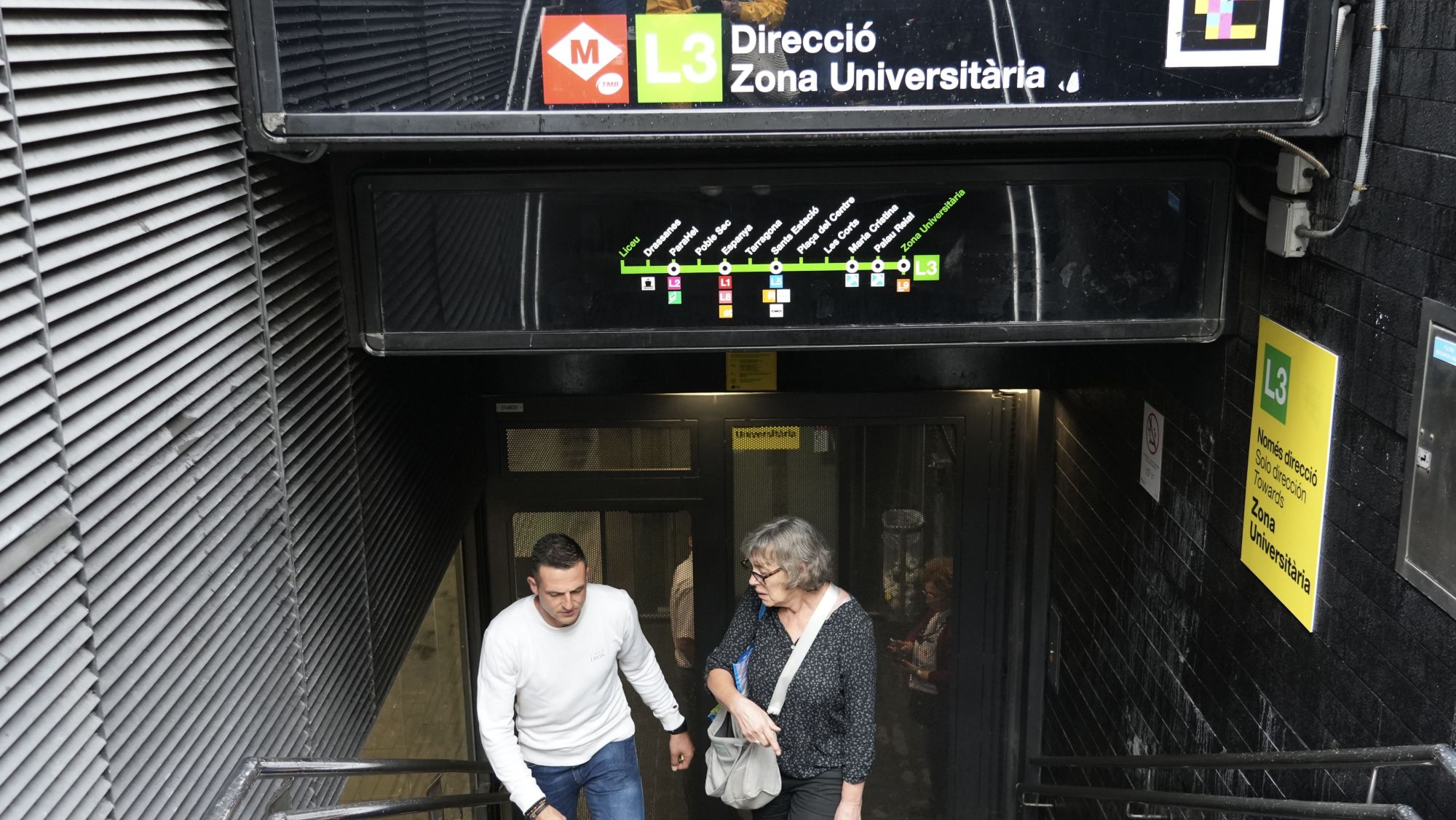 Gent pujant les escales de l'L3 del metro a Liceu, on l'accés està tancat
