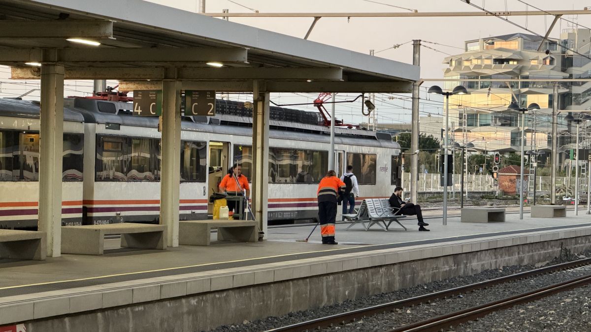 Operaris netejant l'estació de Tarragona en la jornada de vaga de Semaf, amb un comboi esperant en una de les vies
